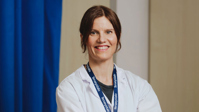 Gynekologi Maria Tuominen vastaanottohuoneessa lääkärintakki yllään. ?? ''