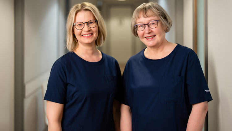 Päivi ja Tuija hymyilevät käytävällä
