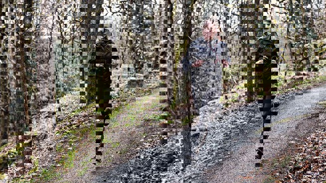 Henkilö juoksee metsäpolulla