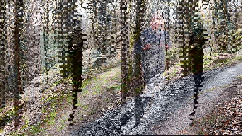 Henkilö juoksee metsäpolulla