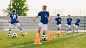 Nuoret jalkapalloilijat tekevät alkuverryttelyä.