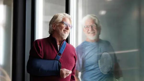 Mies käsi kipsissä