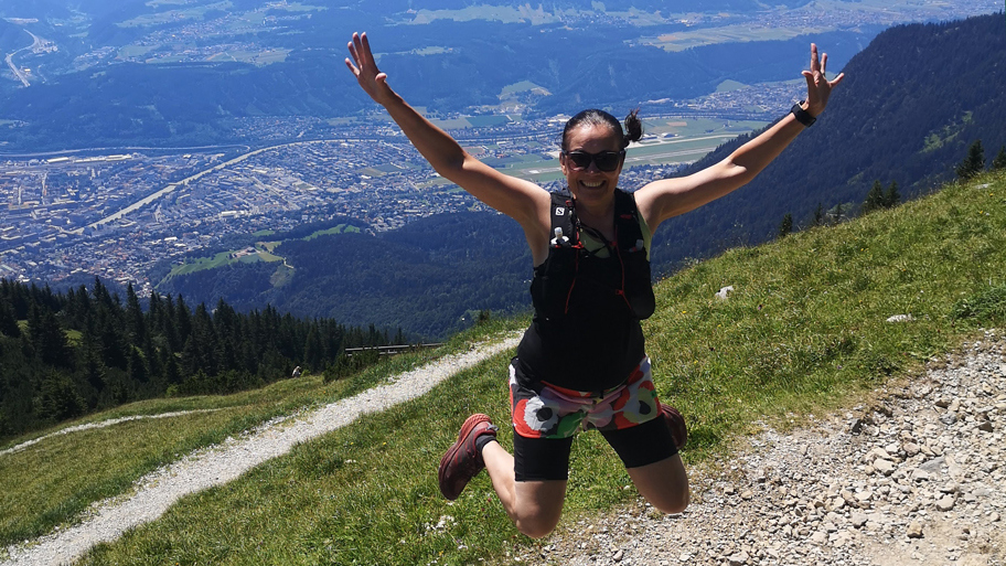 Nina Lyytinen hyppää iloisesti lenkin lomassa vuorilla