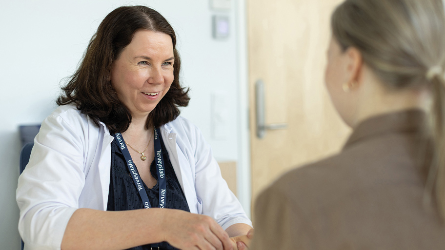 Työterveyslääkäri Minna Korhonen potilaan kanssa vastaanotolla