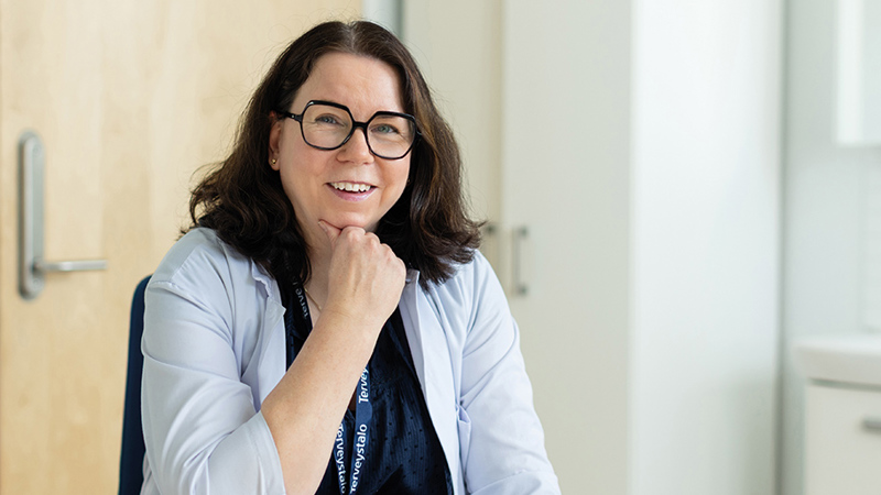 Työterveyshuollon erikoislääkäri Minna Korhonen hymyilee iloisesti.